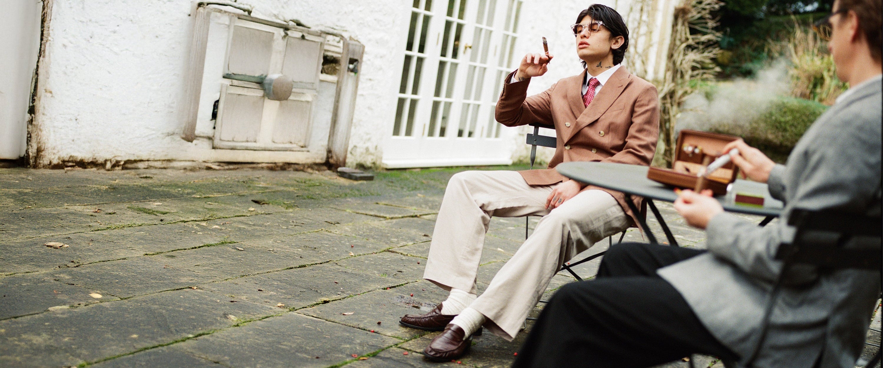 Two people sitting outdoors on a patio.
